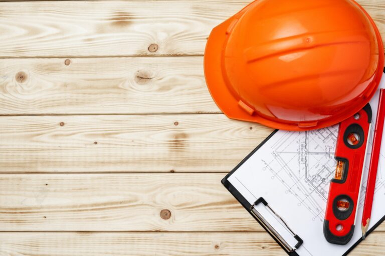 Construction worker hardhat, blueprints and .construction level, top view